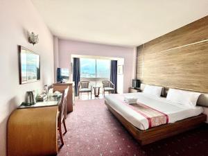 合艾亚洲酒店的酒店客房设有一张大床和一张书桌。
