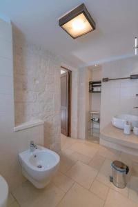 阿尔贝罗贝洛Lunalì的大型浴室设有水槽和浴缸。