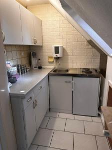 杜伊斯堡A&V Apartments Gemütliche Rheinblick Wohnung的小厨房配有白色橱柜和水槽