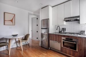 纽约East Village 3br w elevator wd nr parks NYC-1209的厨房配有桌子和不锈钢冰箱。