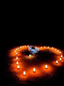 瓦迪拉姆Wild Oryx Camp Bubbles的中间有一只女人和蜡烛的圆圈