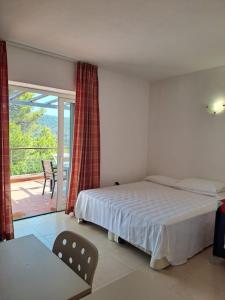 费拉约港阿雷葛罗塔利亚厄尔巴高尔夫酒店的一间卧室配有一张床,享有庭院的景色