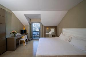 奥尔塔圣朱利奥圣洛可酒店的卧室配有一张白色大床和一张书桌