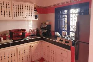 沃利迪耶belle maison vue sur mer的厨房配有白色橱柜和黑色冰箱。