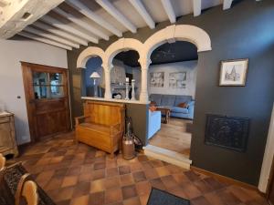 布永Gîte L'Hôte-Antique的一间带拱形天花板的客厅和一间带沙发的房间