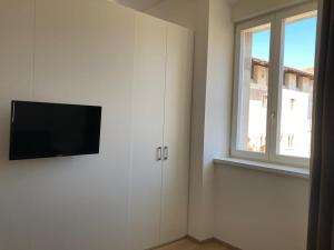 斯尔斯Al Palazzo的一间白色墙壁上配有平面电视的房间