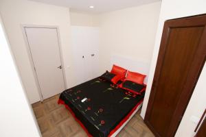 谢赫维蒂利Sweet Home 2 in Shekvetili的一间卧室配有一张带红色枕头的床