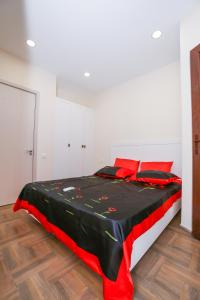 谢赫维蒂利Sweet Home 2 in Shekvetili的一间卧室配有一张带红色枕头的床