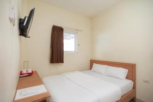 班达楠榜AVA Guesthouse Mitra RedDoorz Lampung的卧室配有白色的床和窗户。