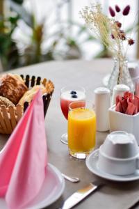 Sint-Gillis-Waas弗鲁特霍夫塔克住宿加早餐旅馆的一张桌子,上面放着一篮面包和一杯橙汁