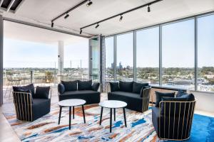 珀斯Vibe Hotel Subiaco Perth的带沙发和桌子的客厅以及大窗户。