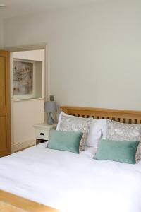 奇彭纳姆克罗姆霍尔农场度假屋 的卧室配有白色床和2个绿色枕头