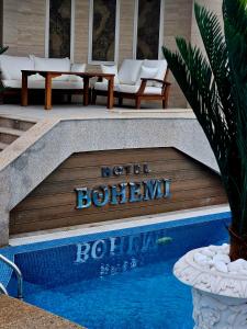哈斯科沃Hotel Bohemi的一个标志,说游泳池旁的酒店波希米亚风格