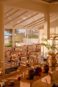 圣埃乌拉利亚Hotel Riomar, Ibiza, a Tribute Portfolio Hotel的一间带木桌和椅子的餐厅以及庭院