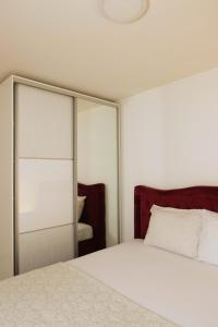 莫斯塔尔Skywalk House的卧室配有白色的床和镜子