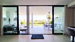 福恩吉罗拉AA Guest - Luxury Paradise Eco Apartment Higueron的一间带玻璃门的客厅和一间餐厅