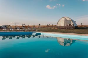 Mandra Lavandiya的一个带椅子的大型游泳池和圆顶建筑