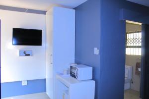 索赫燕杜1 OAK Resort的一间设有蓝色墙壁的客房,配有电视