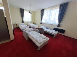 格丁尼亚Figaro Apartaments的一间设有四张床的客房,铺有红地毯