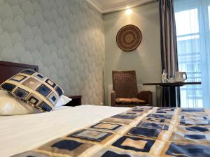 韦尔特African Sky Hotel的卧室配有床、椅子和窗户。