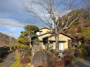 饭田市BANRYU 萬龍 バンリュウ的前面有一棵树的房子