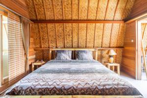 吉利阿尔达梅斯朗邦假日公园的卧室配有一张床铺,位于带木墙的房间内