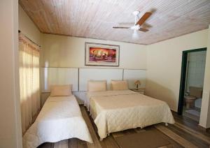 圣若昂-德雷维拉博纳比塔科洛旅馆的一间卧室配有两张床和吊扇