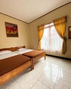 庞岸达兰林贾尼旅馆的一间卧室设有两张床和窗户。