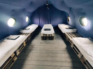 卡尔帕奇Camp66的蓝色墙壁的客房内的三张床