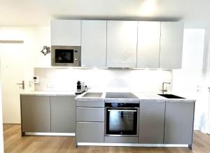 多维尔3 Pièces, Standing, Centre, 2 Sdb, 2 WC, Balcon的厨房配有不锈钢用具和白色橱柜