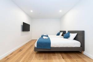 墨尔本Calming Urban Oasis的一间卧室配有一张床,墙上配有电视