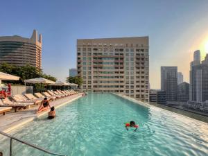 迪拜Welcome Home Apartments - VIDA Marina - Full Marina view - High Floor的一座水面上的人的建筑顶部游泳池