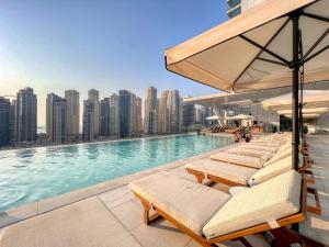 迪拜Welcome Home Apartments - VIDA Marina - Full Marina view - High Floor的游泳池边的一排躺椅