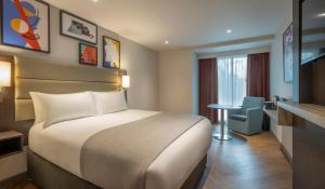 伦敦Maldron Hotel Finsbury Park, London的配有一张床和一张书桌的酒店客房