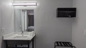 纳舒厄纳舒厄6号汽车旅馆的一间带水槽、镜子和椅子的浴室