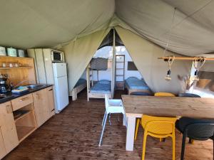 霍尔滕Luxe kamperen bij Procamp4all的帐篷的厨房和用餐区配有桌椅