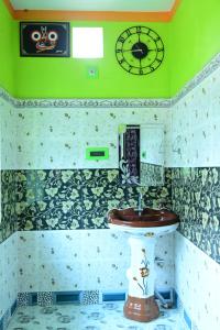 科纳卡HOLIDAY INN的一间带水槽和墙上时钟的浴室