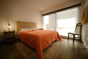 Faja GrandeFonte da Via的一间卧室配有一张带橙色毯子和窗户的床。
