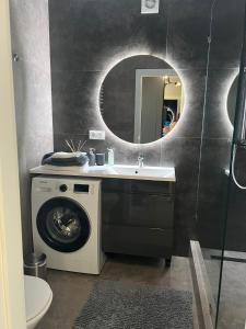 捷尔诺波尔Стильна чудова квартира в місті Тернопіль的一间带洗衣机和水槽的浴室