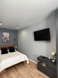捷尔诺波尔Стильна чудова квартира в місті Тернопіль的一间卧室配有一张床和一台平面电视