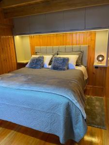 坎巴拉Hospedaria Cambará的卧室设有一张大床,卧室设有木墙