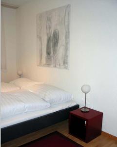 楚格Nest - Poststrasse 24的卧室配有一张床,墙上挂着一幅画