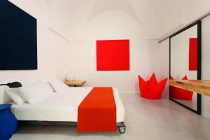 奥斯图尼Casa Campari的卧室配有红色和白色的床和红色艺术品