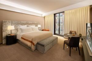 伦敦Bulgari Hotel London的配有一张床、一张桌子和一张桌子的酒店客房