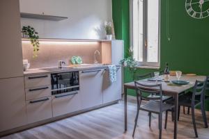帕尔马BDC_7 Apartment的一间带桌子的厨房和一间带绿色墙壁的厨房