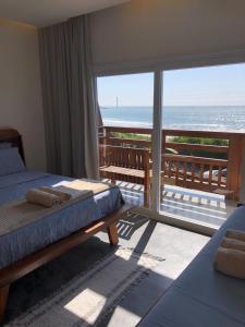 佩尼亚Pousada Casa Albatross的一间带两张床的卧室,享有海景
