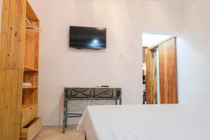 福塔莱萨Hotel pousada Krone Praia de Iracema Fortaleza的卧室配有一张床,墙上配有电视。