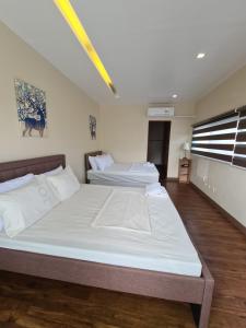 大雅台Serenity Home near Ayala Malls Serin的一间卧室设有两张床和窗户。