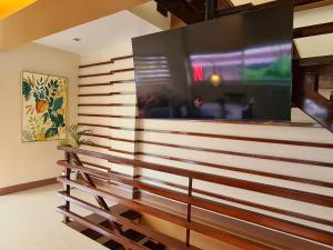 大雅台Serenity Home near Ayala Malls Serin的墙上的大屏幕平面电视