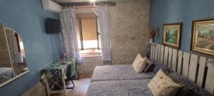 奥卡尼亚Habitación en Ocaña的一间拥有蓝色墙壁的卧室、一张床和窗户